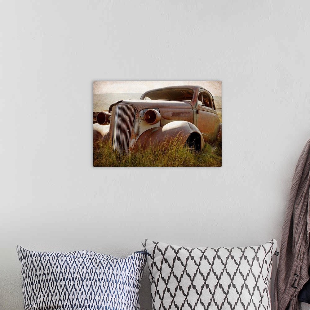 A bohemian room featuring Photograph of a broken down and beat up vintage car in a junkyard.