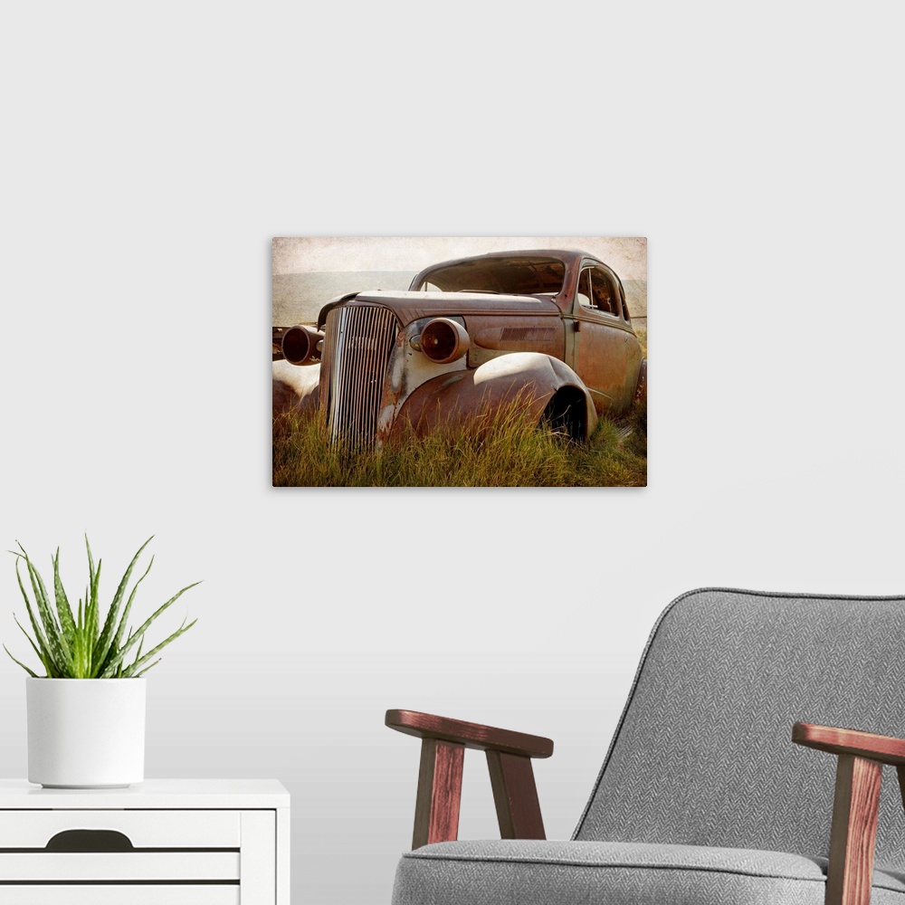 A modern room featuring Photograph of a broken down and beat up vintage car in a junkyard.