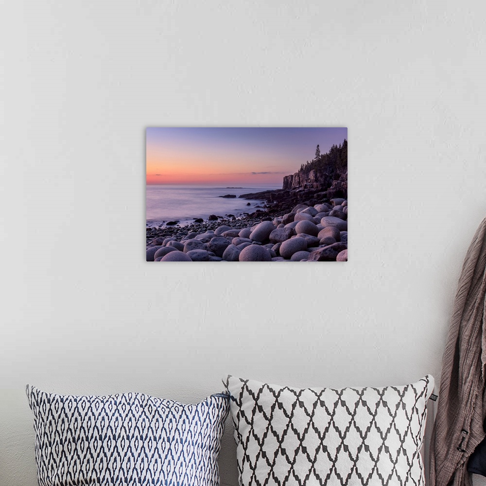 A bohemian room featuring Landscape photograph of a rocky beach shore with a warm sunrise.