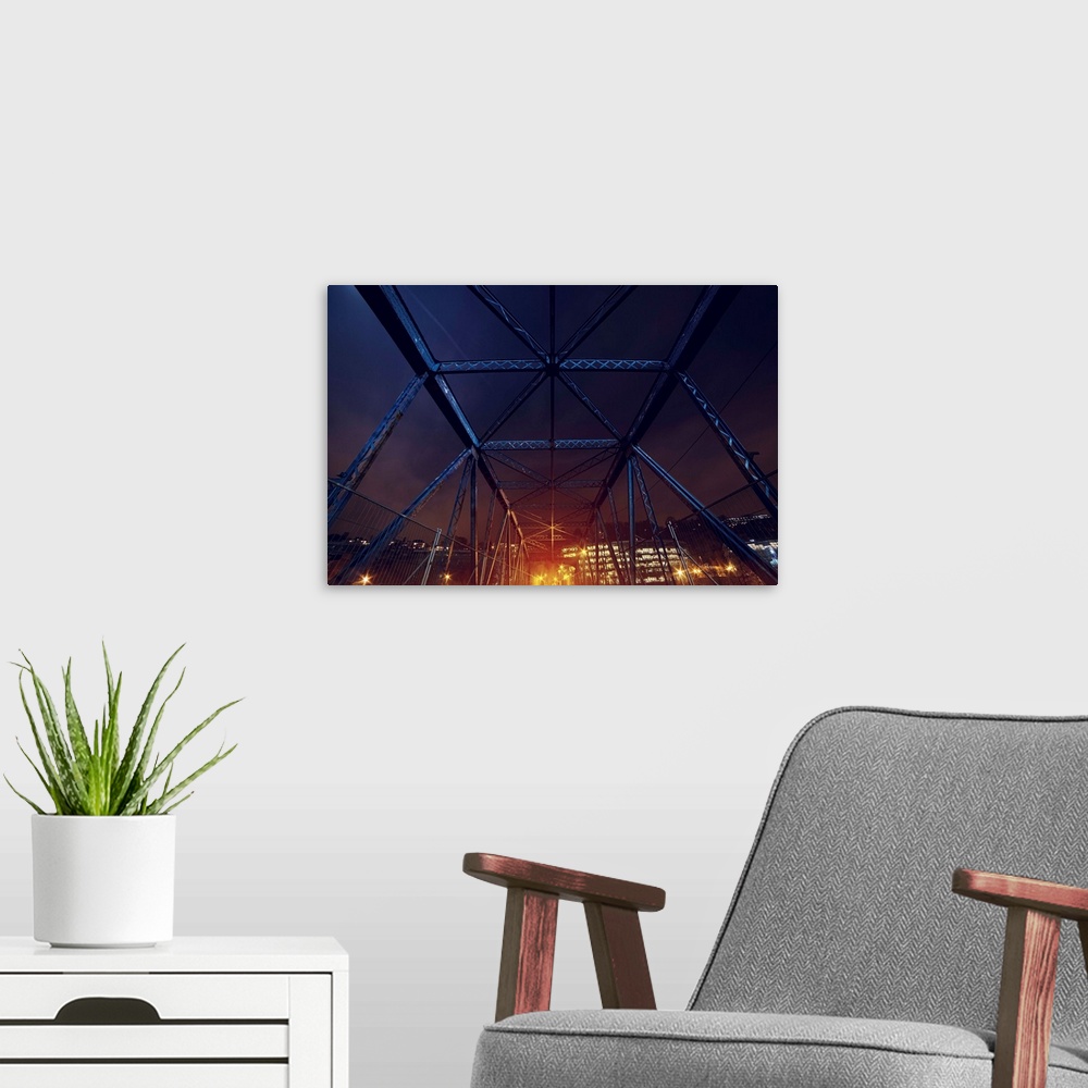 A modern room featuring An HDR photograph of an urban area seen through the frame of a bridge.
