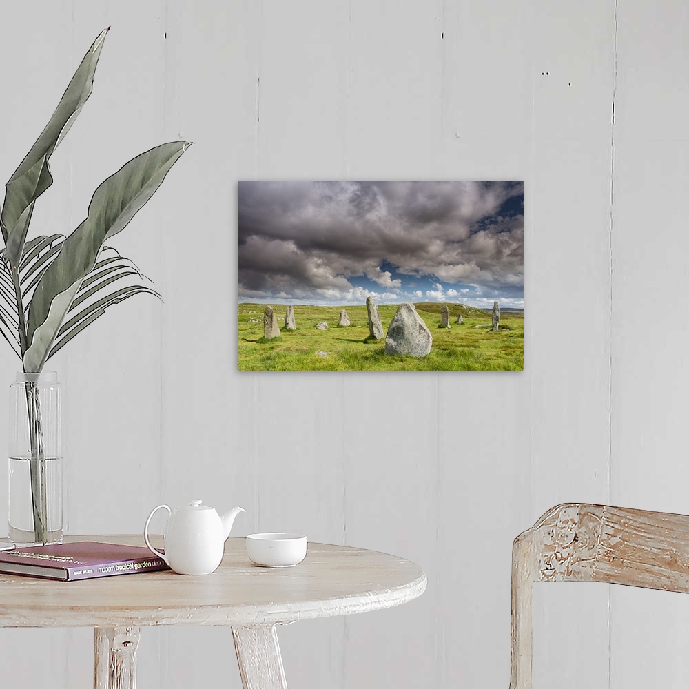 A farmhouse room featuring A photograph of a group of monolith stones in Scotland.