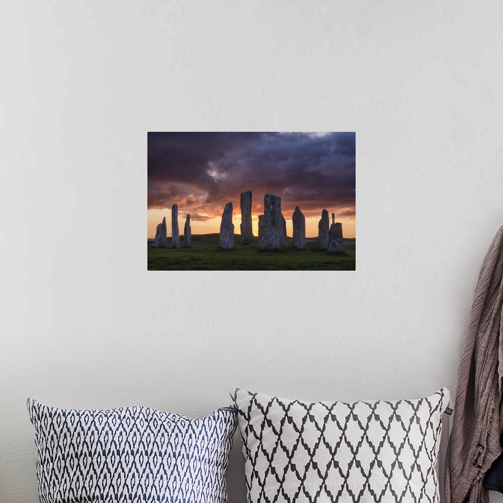 A bohemian room featuring Photograph of ancient rock ruins in Scotland, under aggressive looking clouds.