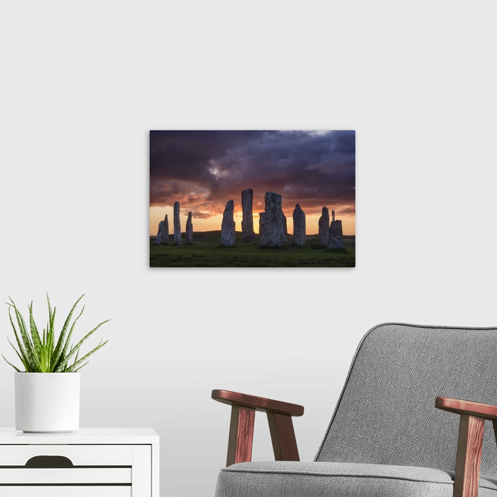 A modern room featuring Photograph of ancient rock ruins in Scotland, under aggressive looking clouds.