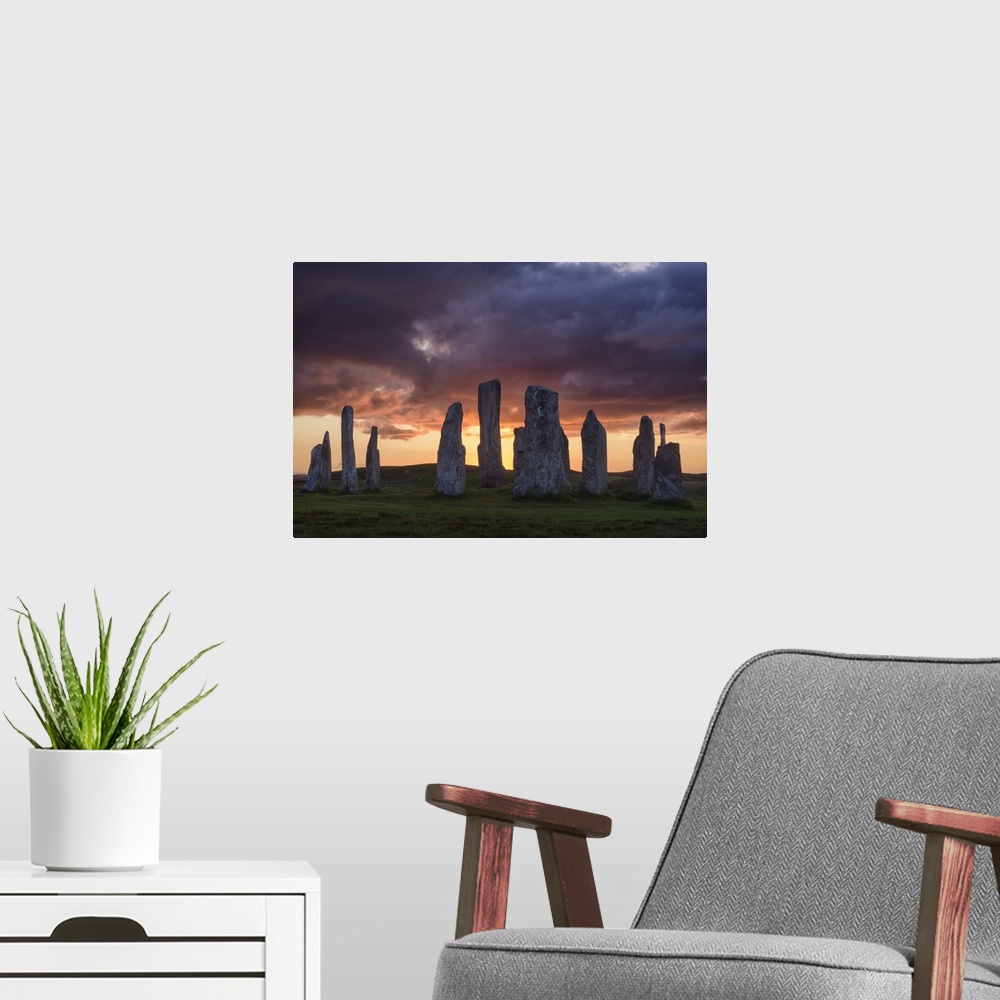 A modern room featuring Photograph of ancient rock ruins in Scotland, under aggressive looking clouds.