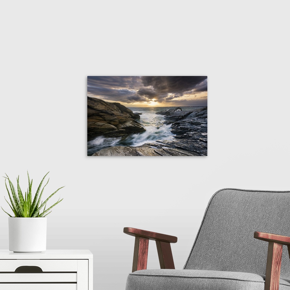 A modern room featuring Landscape photograph of a dramatic, cloudy sky over water rushing through a rocky path.