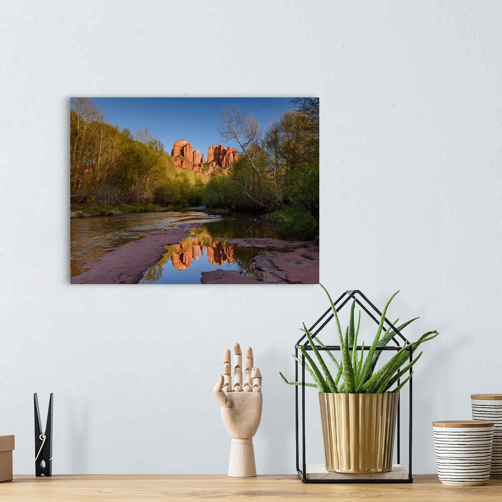 A bohemian room featuring Landscape photograph of Cathedral Rock reflecting into a low, rocky river, Sedona AZ.
