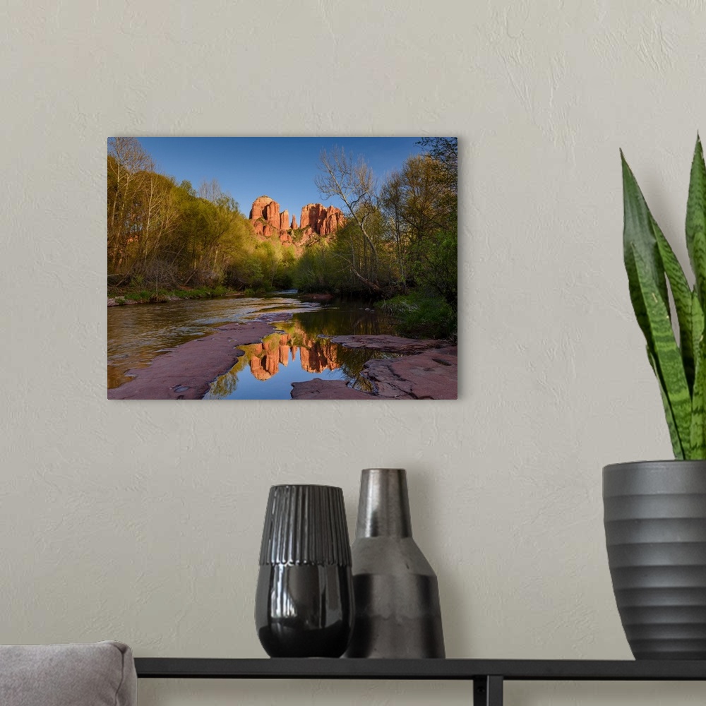A modern room featuring Landscape photograph of Cathedral Rock reflecting into a low, rocky river, Sedona AZ.