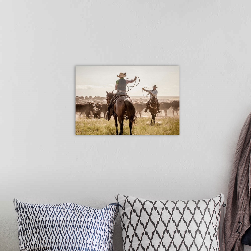 A bohemian room featuring Photograph of two cowboys with their lassos in the air while herding cattle.