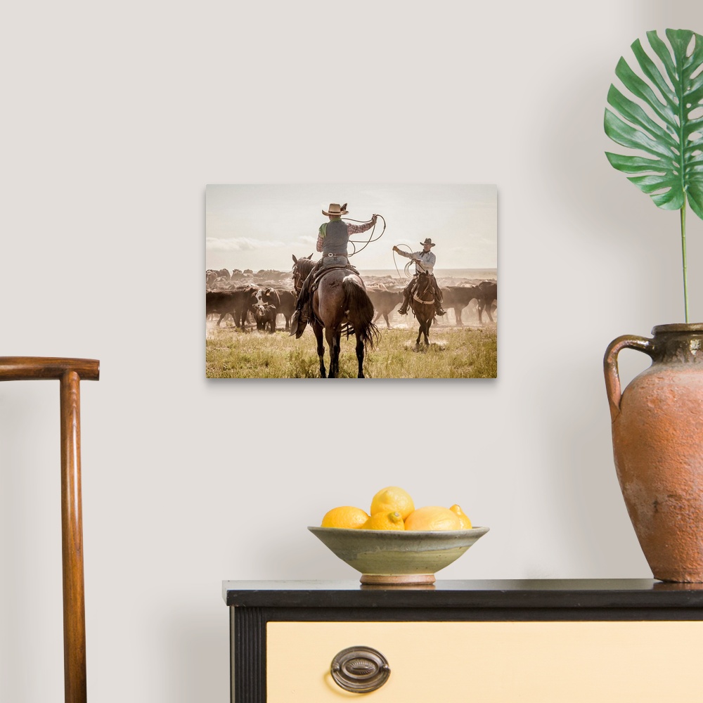 A traditional room featuring Photograph of two cowboys with their lassos in the air while herding cattle.