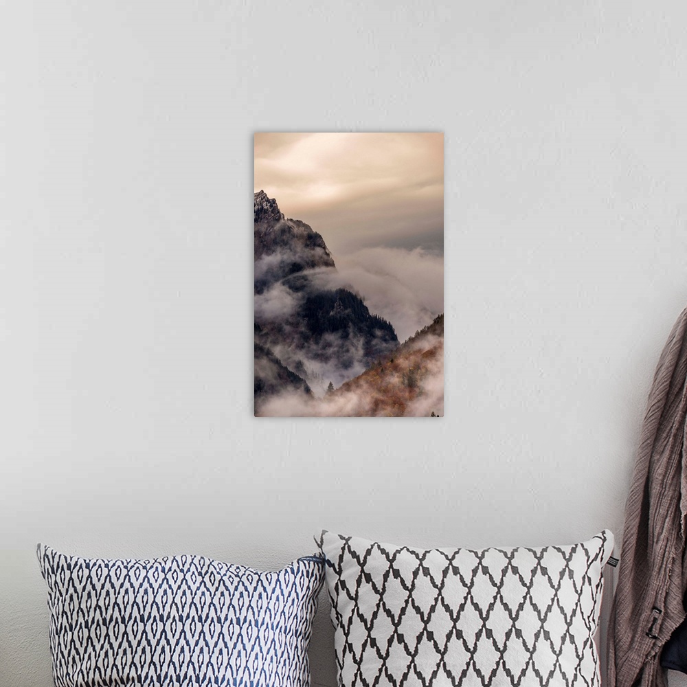 A bohemian room featuring Landscape photograph of foggy mountain cliffs.