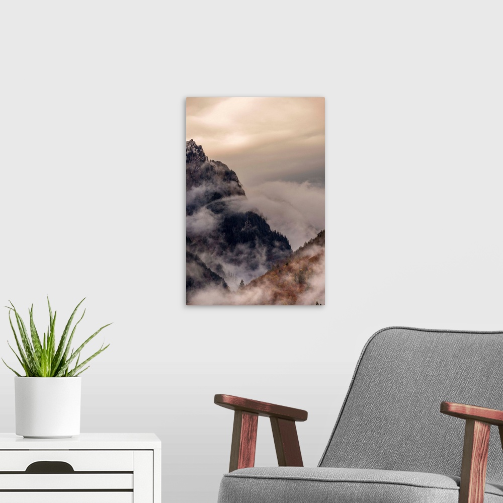A modern room featuring Landscape photograph of foggy mountain cliffs.