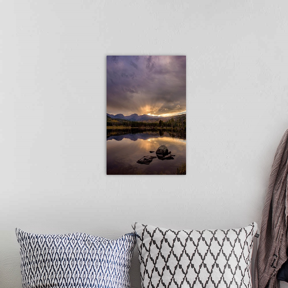 A bohemian room featuring Landscape photograph of trees and mountains reflecting onto a calm lake at sunset.