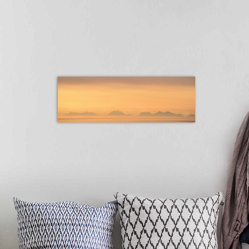 A bohemian room featuring Landscape photograph of a cloudy mountain range with warm hues.