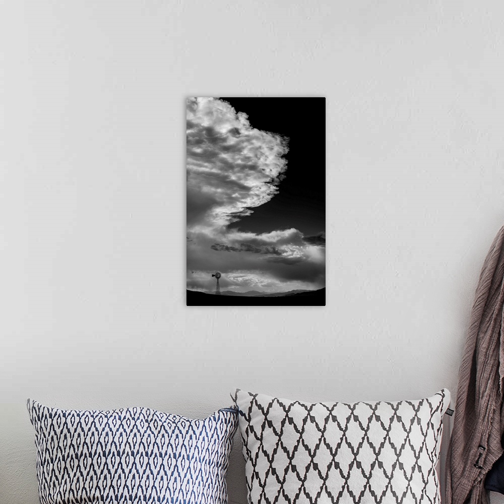 A bohemian room featuring Black and white photograph of a beautiful cloudy sky with a windmill silhouette in the distance.