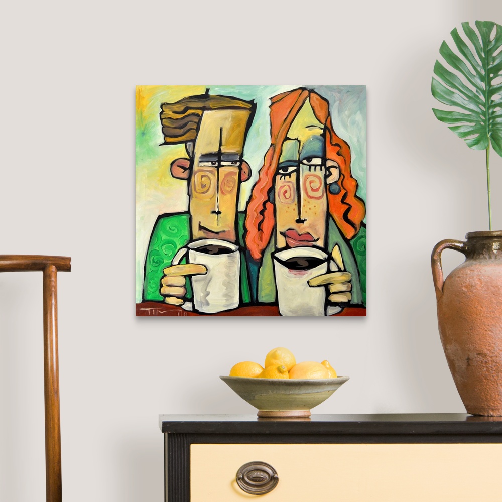 A traditional room featuring Square painting of two cartoon like figures enjoying mugs of coffee.