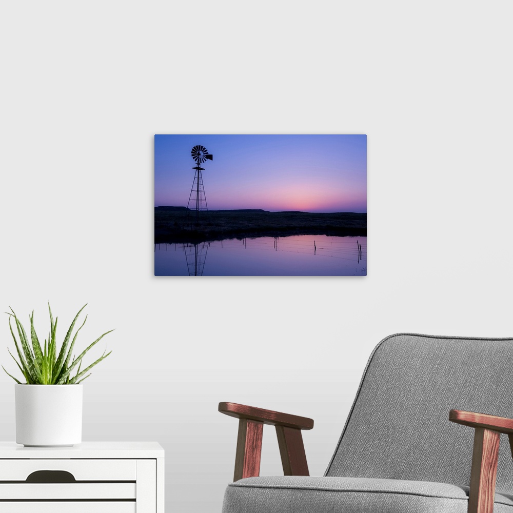 A modern room featuring windmill in by the water at sunset