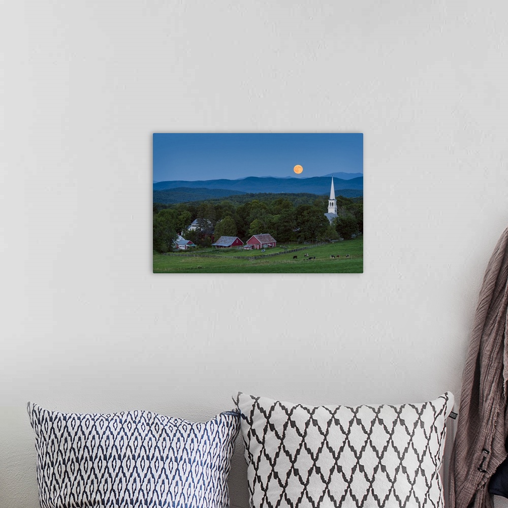 A bohemian room featuring A photograph of a small village in the countryside seen at night under a clear sky and a full moon.