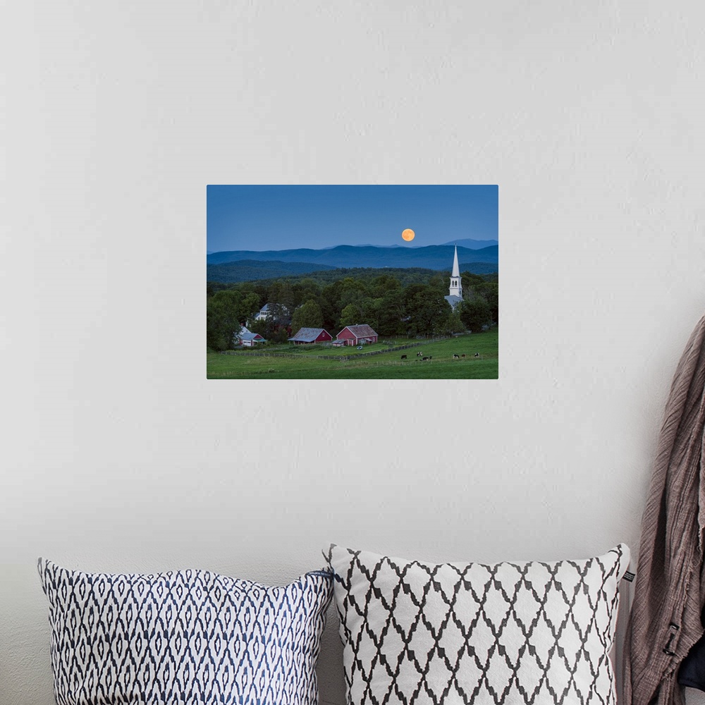 A bohemian room featuring A photograph of a small village in the countryside seen at night under a clear sky and a full moon.
