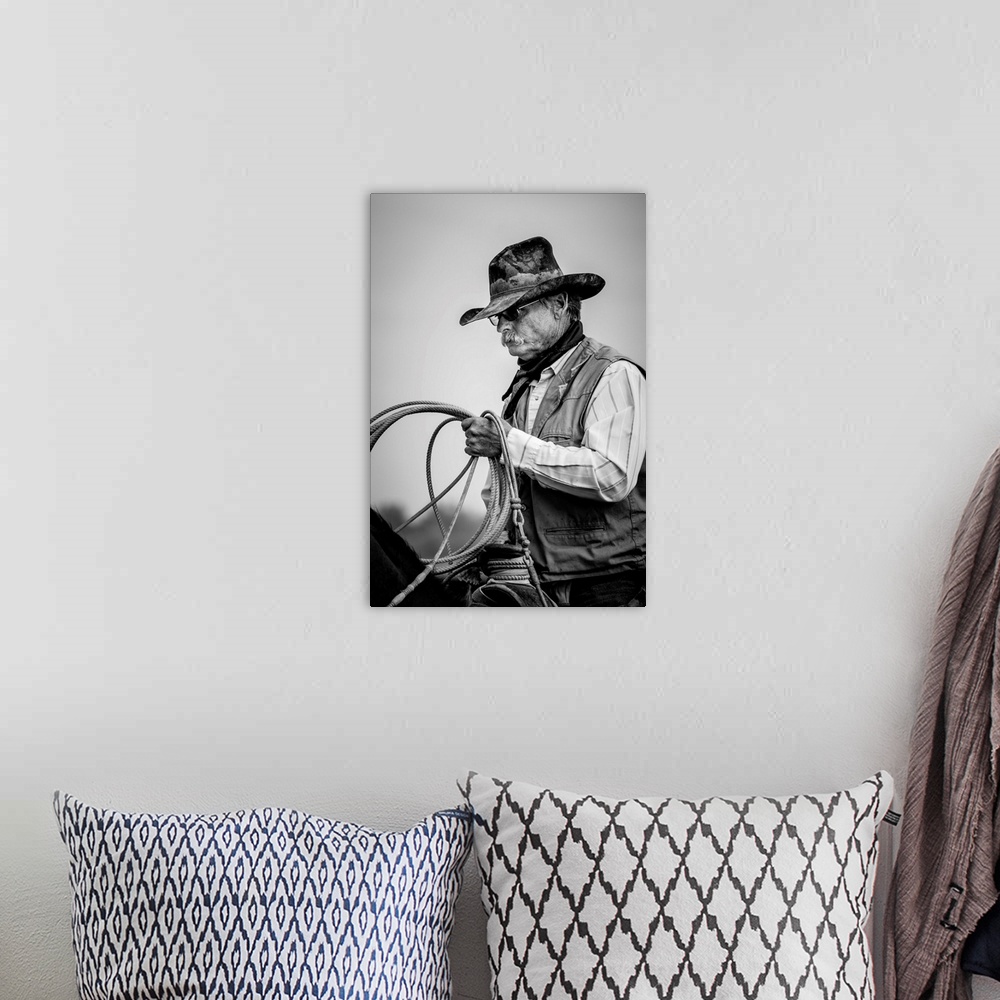 A bohemian room featuring Black and white portrait of a cowboy  holding a lasso.