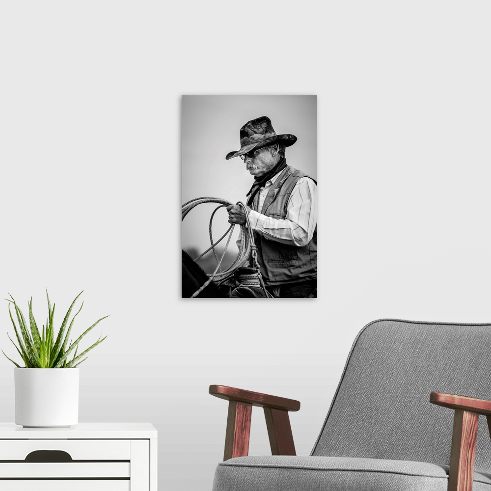 A modern room featuring Black and white portrait of a cowboy  holding a lasso.