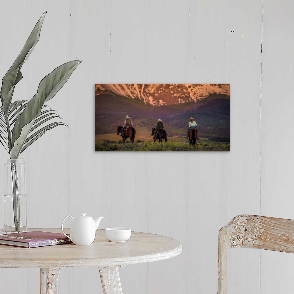 A farmhouse room featuring Photograph of three cowgirls on horseback from behind, heading towards the mountains at sunset.