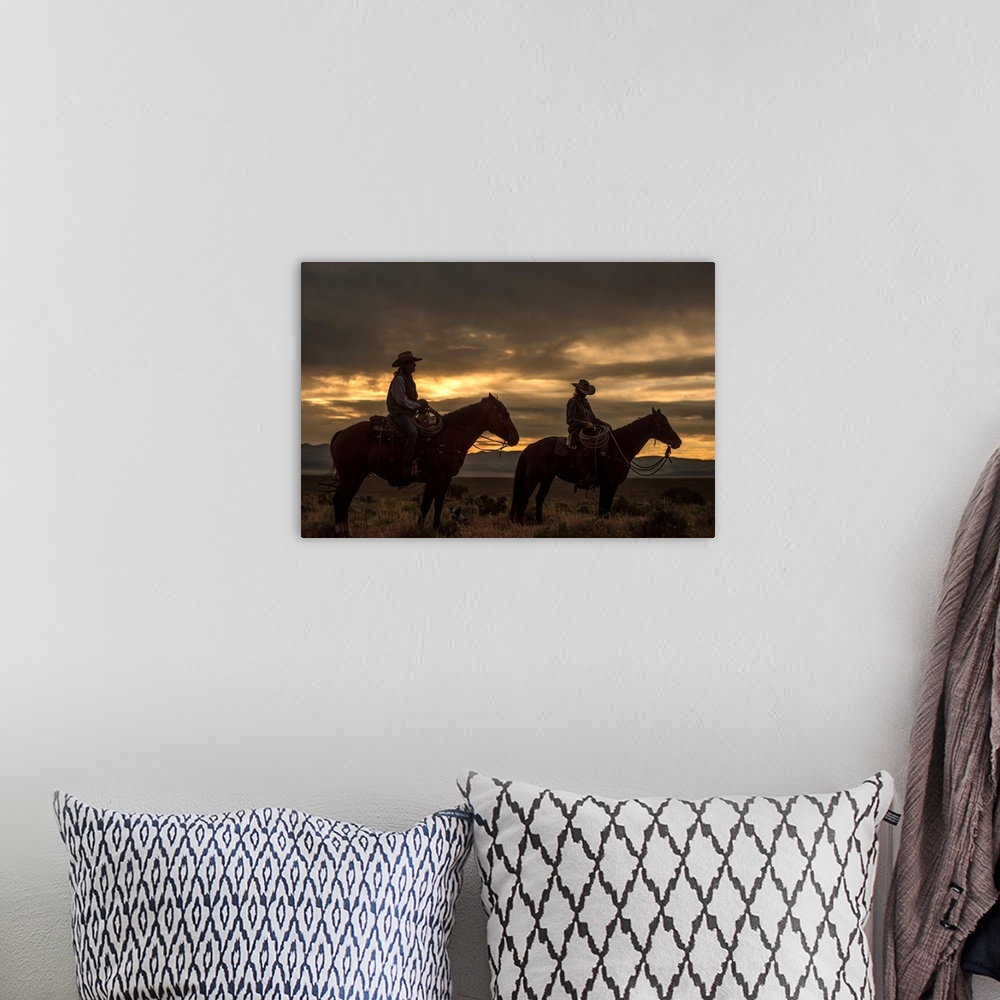 A bohemian room featuring Low-key photograph of two women on horseback with a dog lying on the ground at dusk.