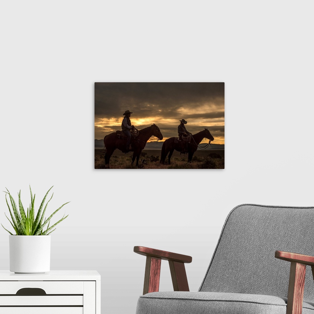 A modern room featuring Low-key photograph of two women on horseback with a dog lying on the ground at dusk.