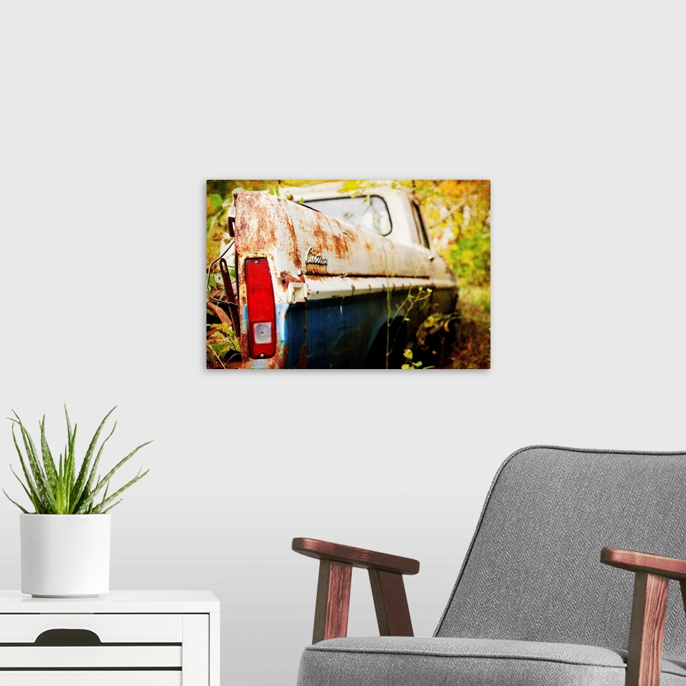 A modern room featuring Photograph of a derelict truck in the woods.