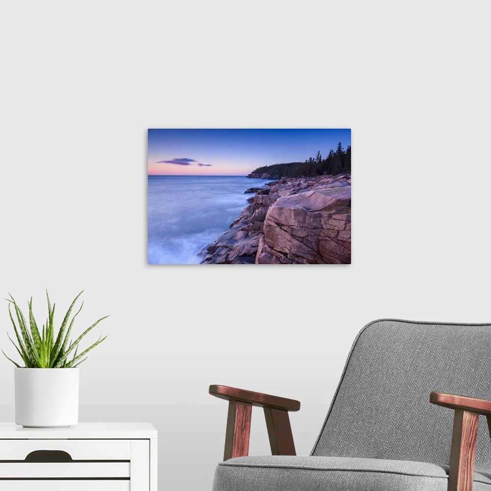 A modern room featuring Long exposure photograph of an ocean leading up to rocky cliffs\ early in the morning.