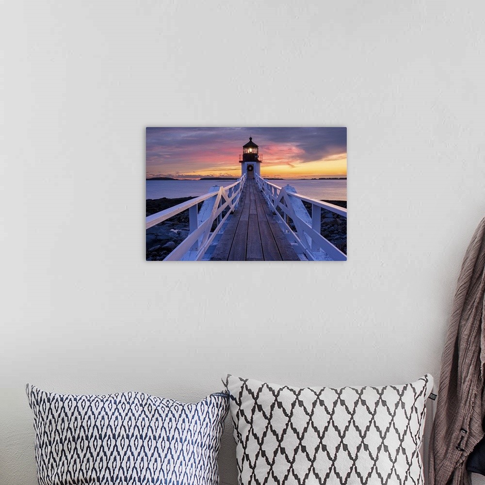A bohemian room featuring A photograph of a lighthouse under a sunset sky.