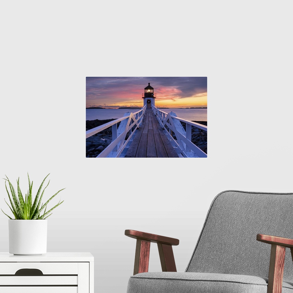 A modern room featuring A photograph of a lighthouse under a sunset sky.