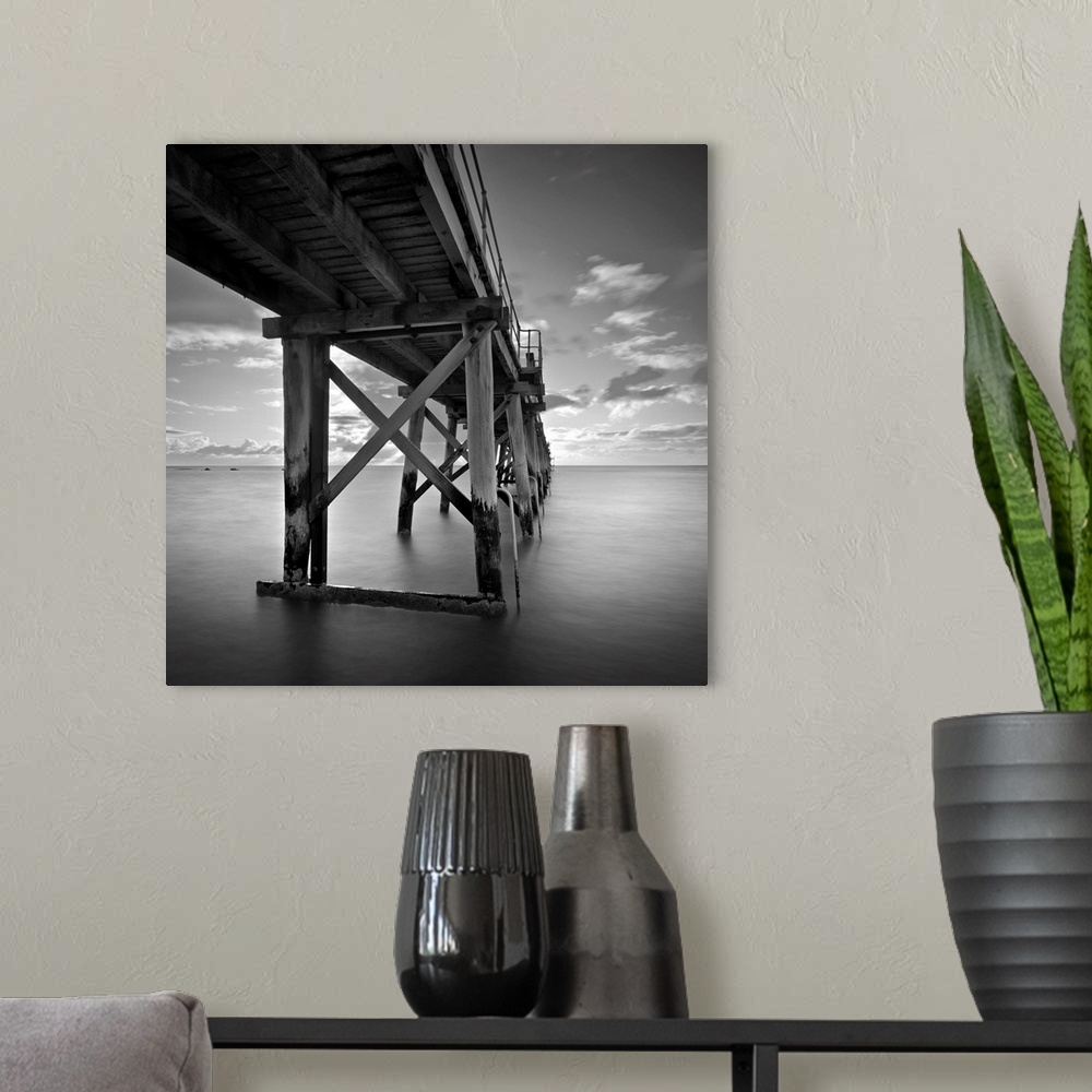A modern room featuring A black and white photograph of a pier jetting out over the ocean.