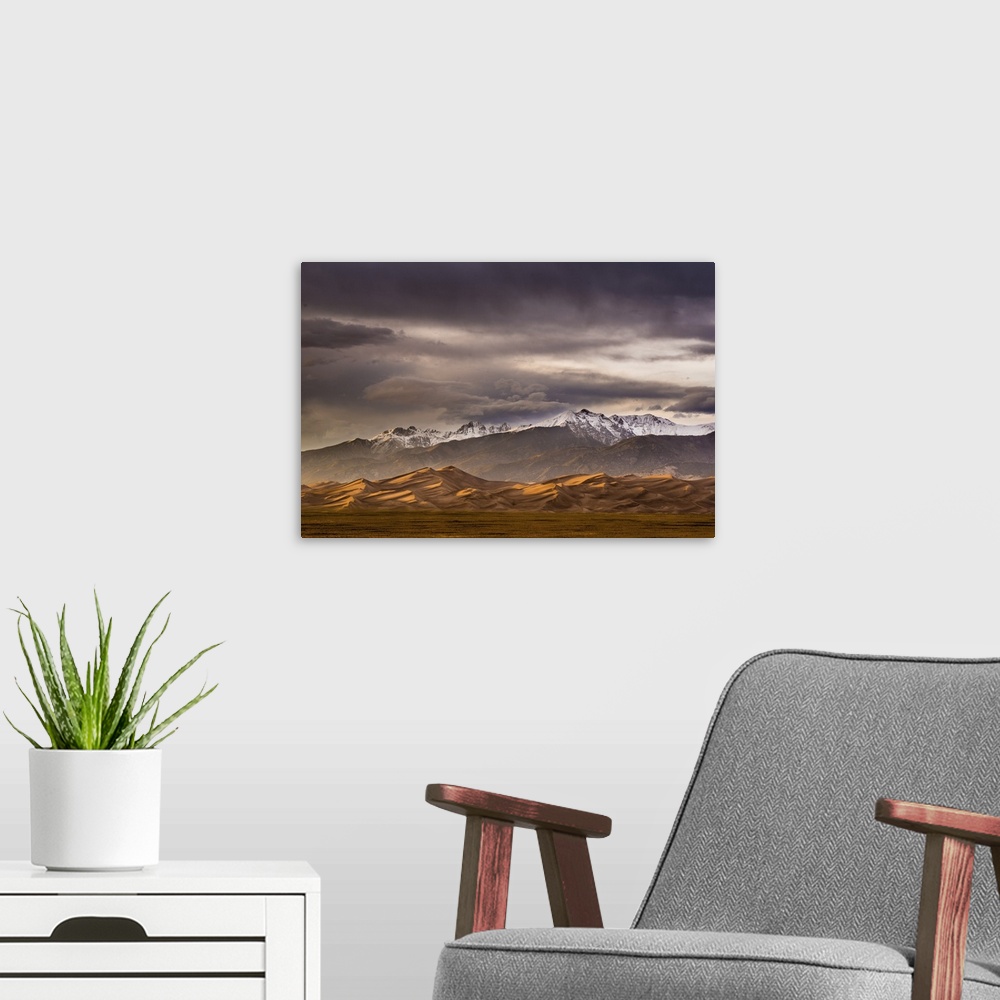 A modern room featuring A photograph of mountain under dramatic clouds illuminated by the sunset.