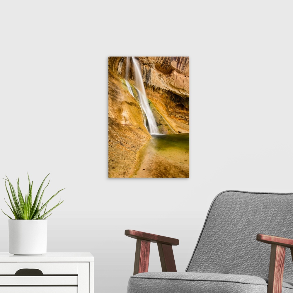 A modern room featuring A photograph of a small waterfall streaming down a desert rock wall in an oasis.
