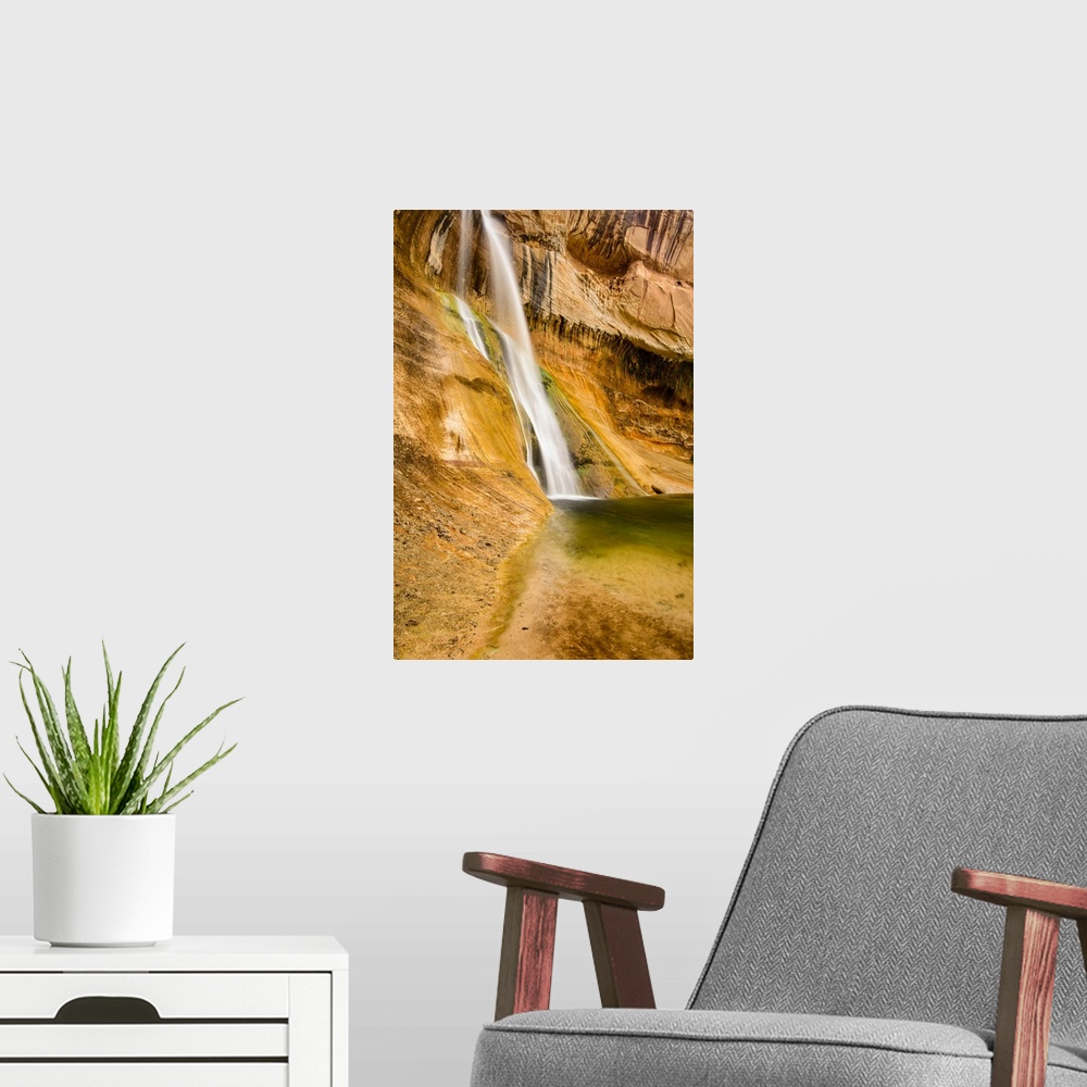 A modern room featuring A photograph of a small waterfall streaming down a desert rock wall in an oasis.