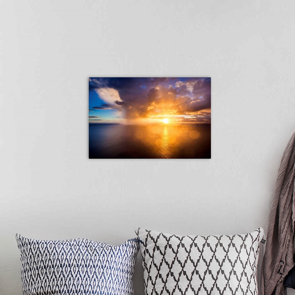 A bohemian room featuring A photograph of a Hawaiian sunset over the ocean.