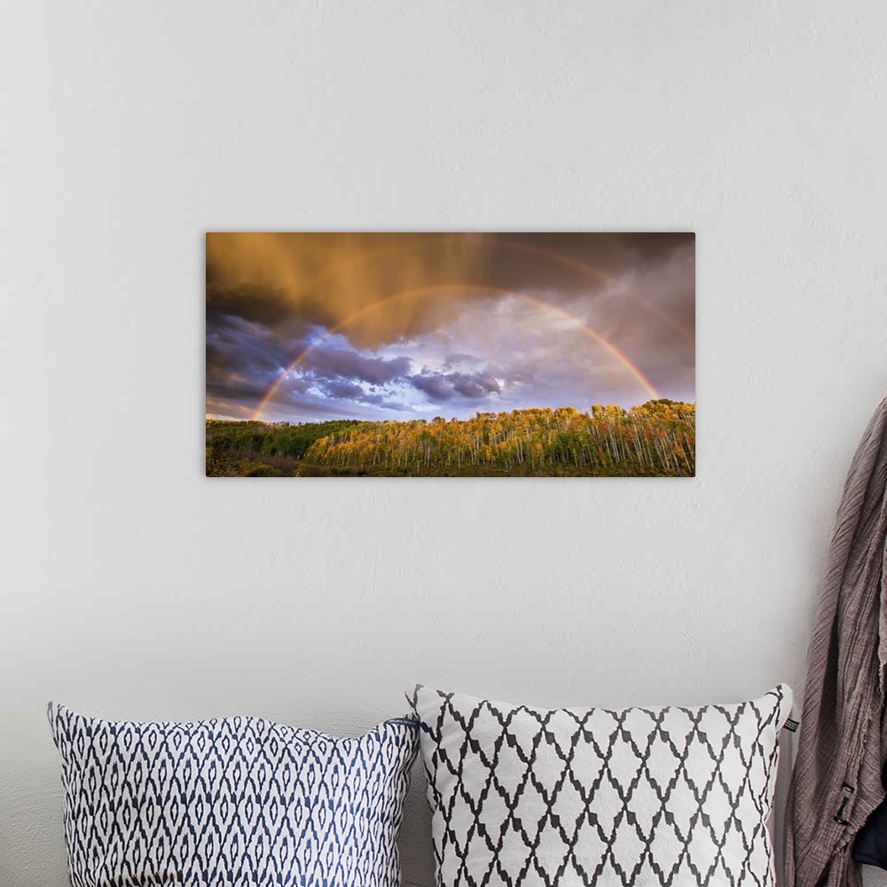 A bohemian room featuring A photograph of a double rainbow over a countryside landscape.