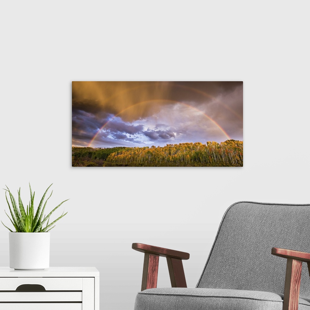 A modern room featuring A photograph of a double rainbow over a countryside landscape.