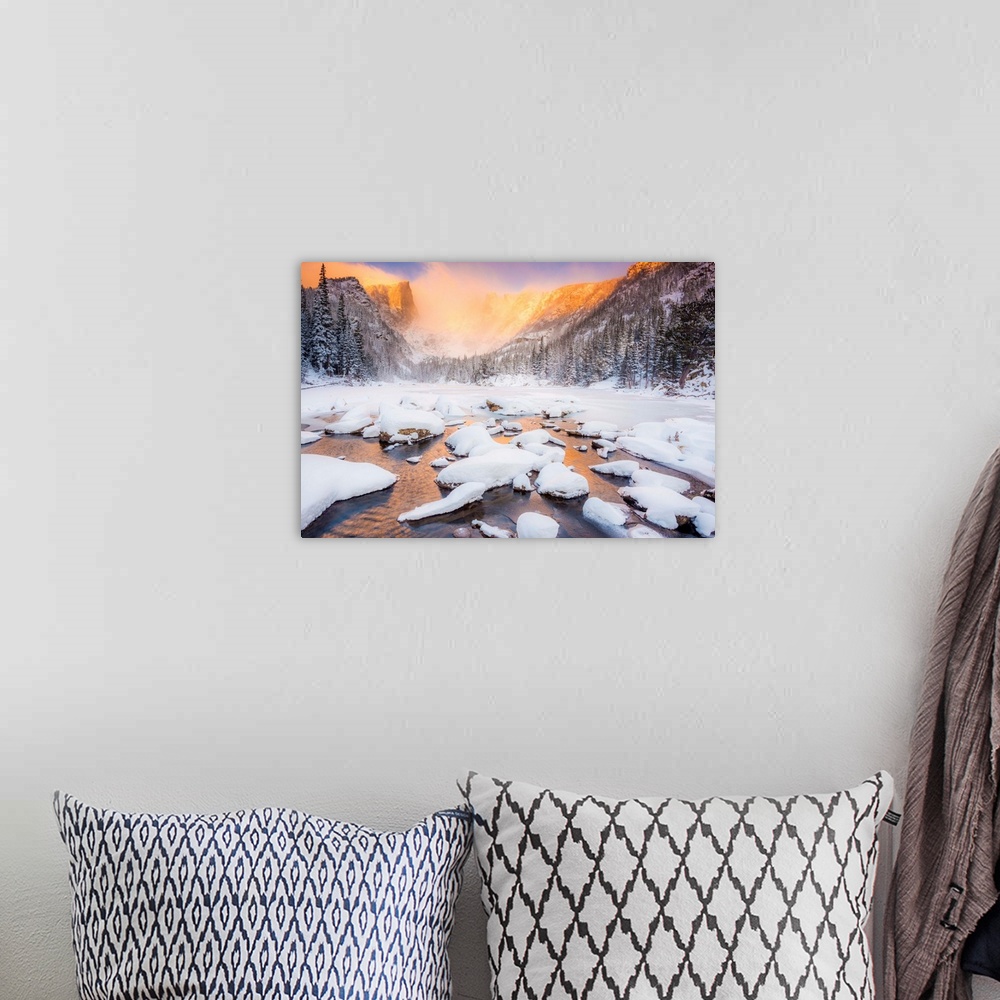 A bohemian room featuring Snow on the water, under the mountains.