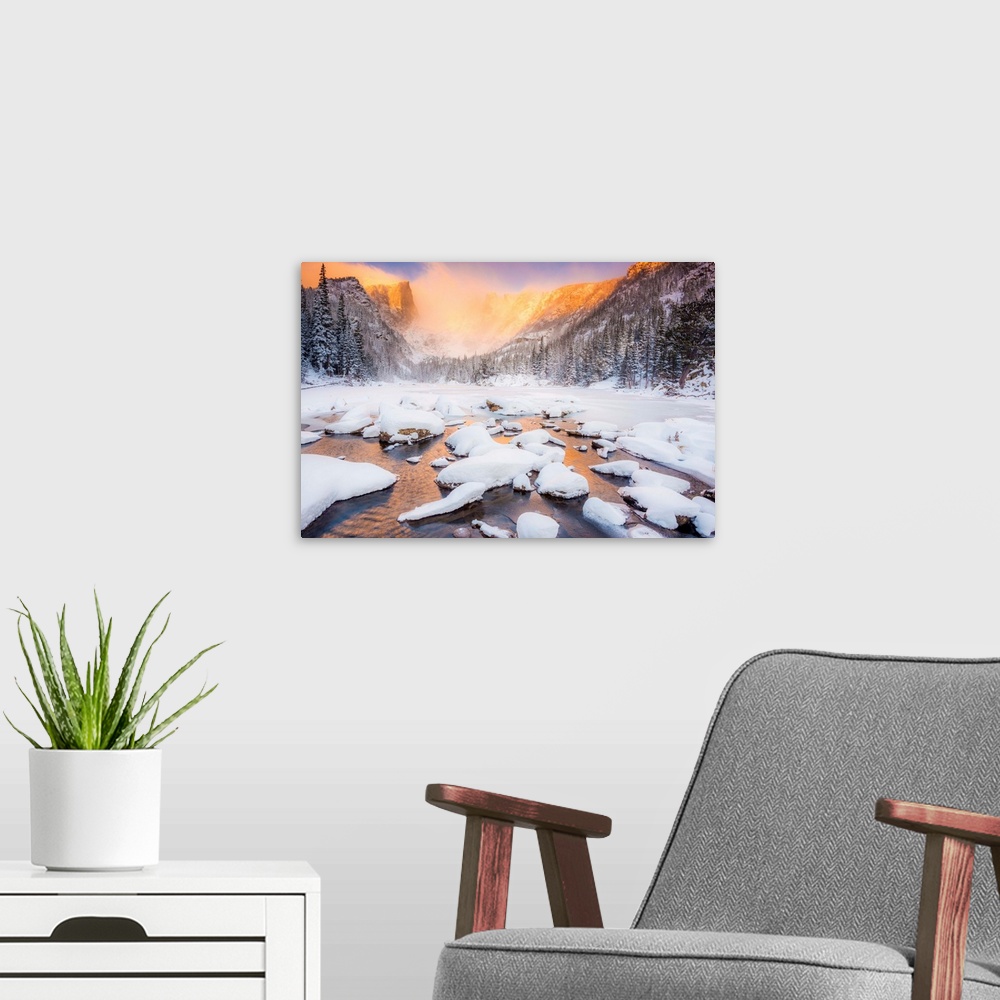 A modern room featuring Snow on the water, under the mountains.