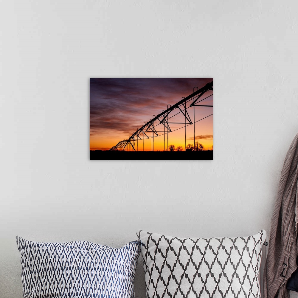 A bohemian room featuring Beautiful sunset photograph with a silhouette of a farms irrigation system.