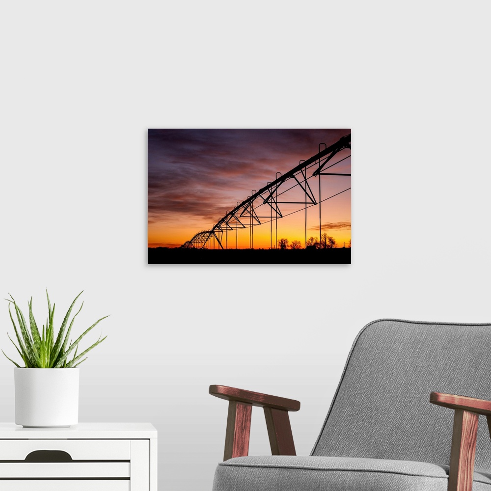 A modern room featuring Beautiful sunset photograph with a silhouette of a farms irrigation system.