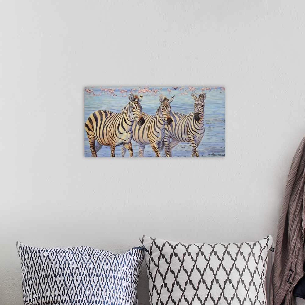 A bohemian room featuring Three zebras walking through water with a flock of flamingos in the background