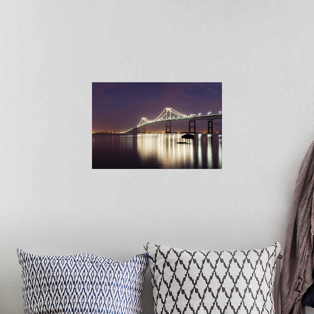 A bohemian room featuring A photograph of a large suspension bridge seen lit up at night casting long reflections on the wa...
