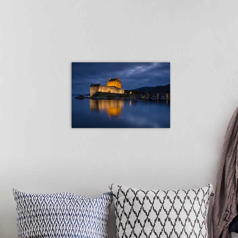 A bohemian room featuring A photograph of the Eilean Donan castle in Scotland seen at night.