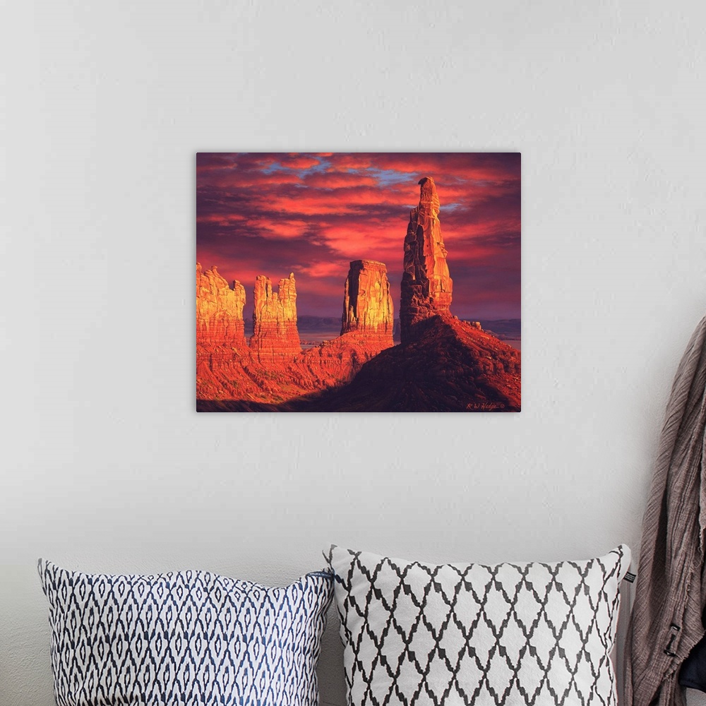 A bohemian room featuring The sun setting on plateaus in Monument valley.