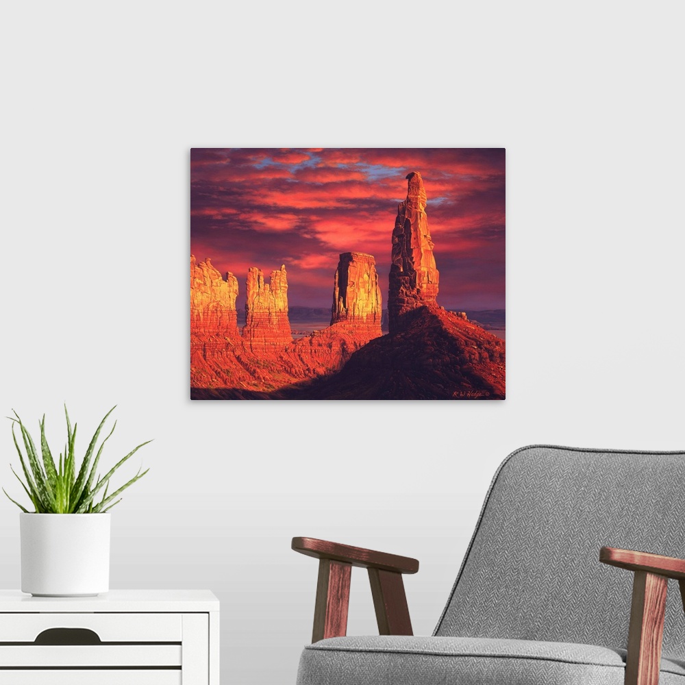 A modern room featuring The sun setting on plateaus in Monument valley.