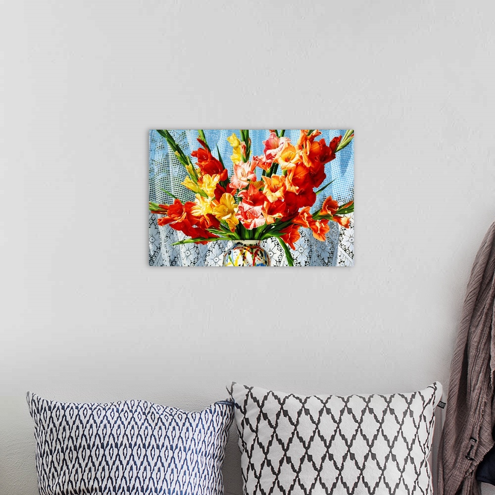 A bohemian room featuring Contemporary vivid realistic still-life painting of bright red orange and yellow flowers in a mul...