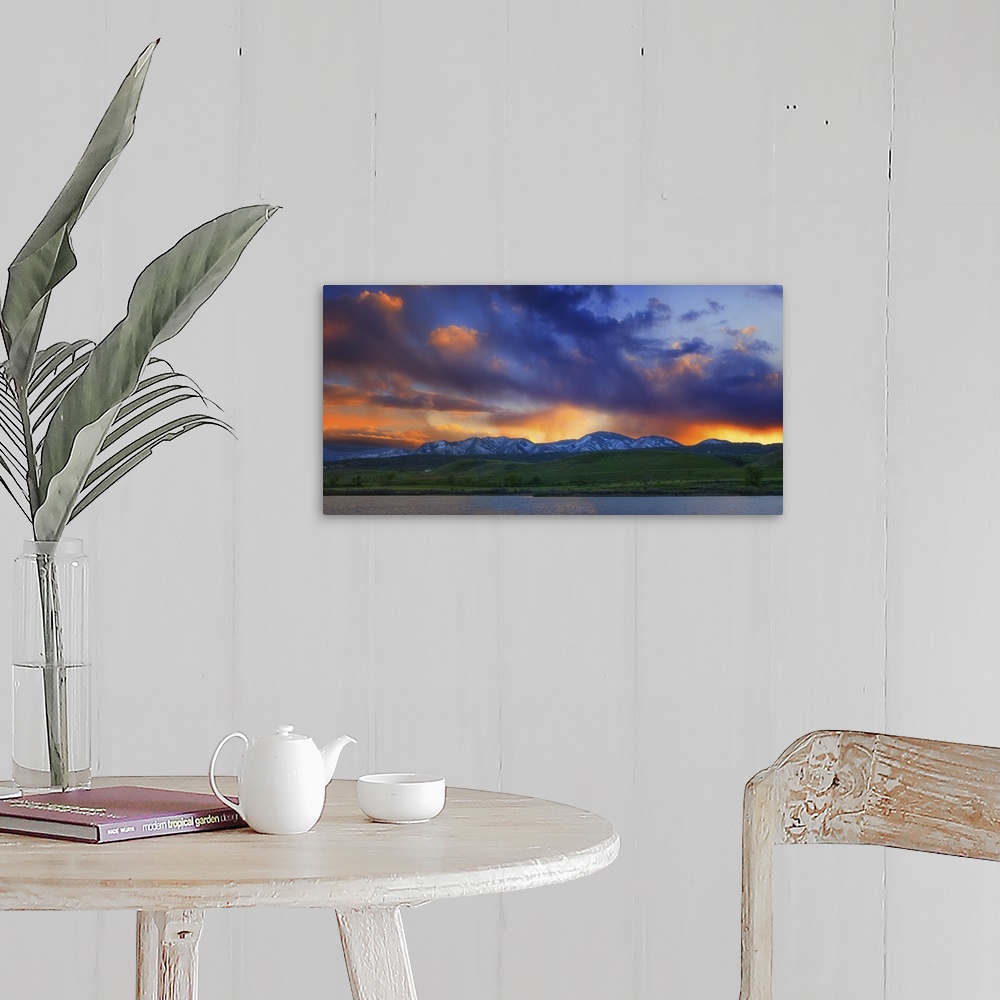 A farmhouse room featuring Vivid clouds at sunset over a mountain range.