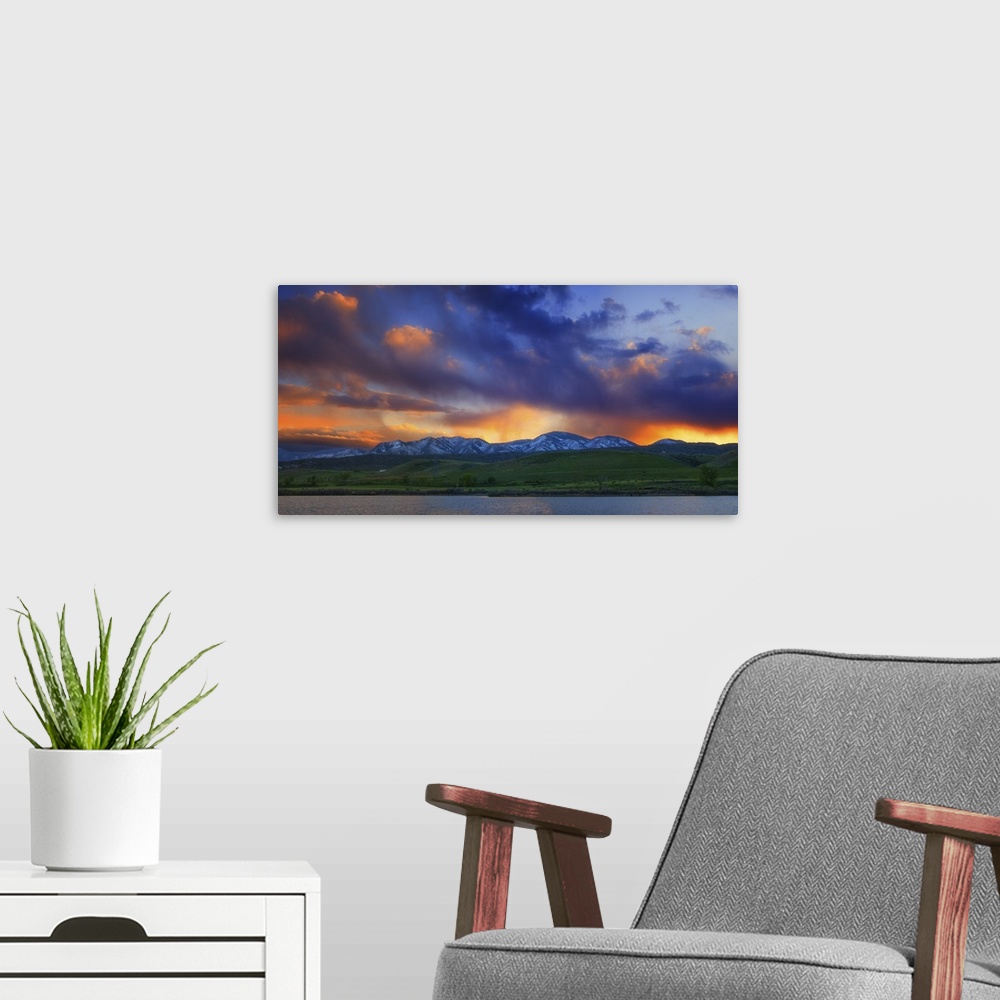 A modern room featuring Vivid clouds at sunset over a mountain range.
